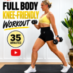 Penny Barnshaw, Garage Fitness Girl 2 Garage Fitness Girl Woman over 40 holding dumbbells in a standing split stance for a 35 minute all standing full body knee friendly workout